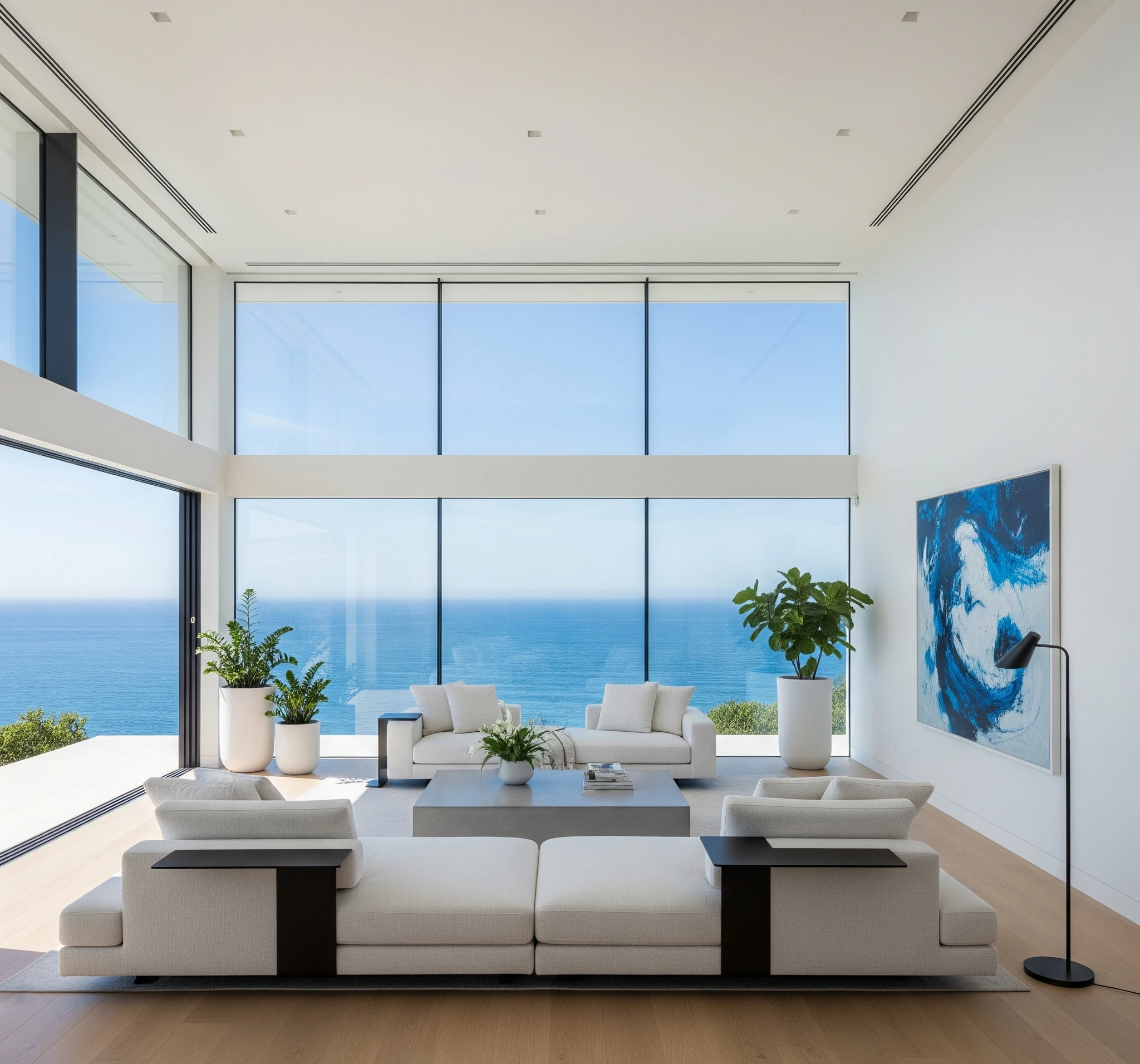 Minimalist living room with floor-to-ceiling windows overlooking the ocean.